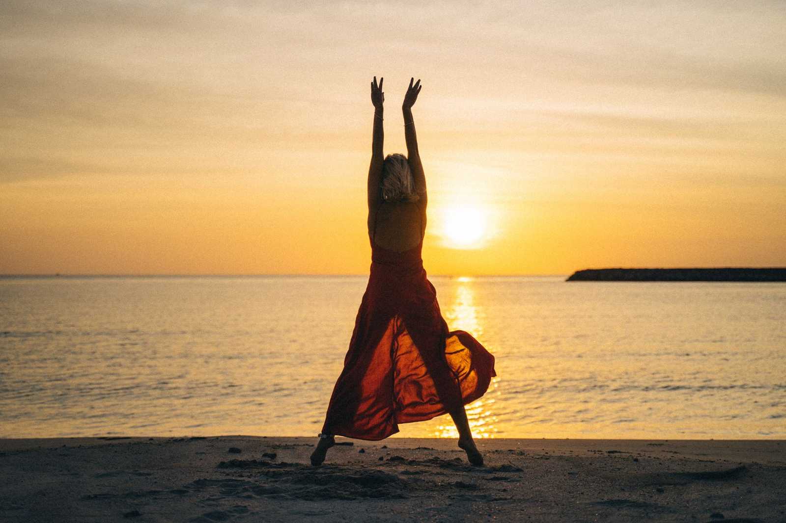 Woman with open hands at sunrise